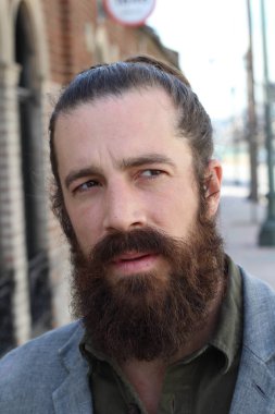 Tarz sahibi sakallı hippi modeli. Erkek saç stili, sokakta yaşam tarzı, tarlanın derinliği.