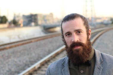 Tarz sahibi sakallı hippi modeli. Erkek saç stili, sokakta yaşam tarzı, tarlanın derinliği.