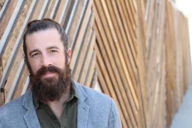 Tarz sahibi sakallı hippi modeli. Erkek saç stili, sokakta yaşam tarzı, tarlanın derinliği.