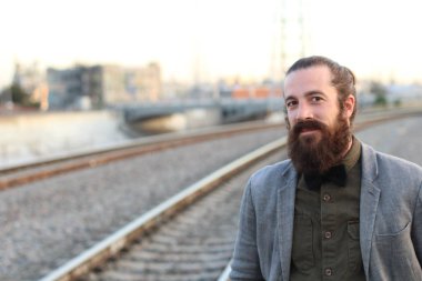 Tarz sahibi sakallı hippi modeli. Erkek saç stili, sokakta yaşam tarzı, tarlanın derinliği.