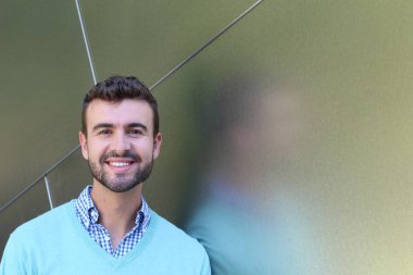 İşaretli gömlekli genç bir adam portresi ve kolları çapraz duran cyan süveter.