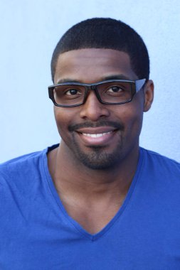 Portrait of a nice young attractive African man in blue t-shirt and eyeglasses 