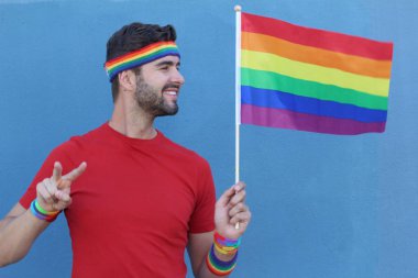 Yakışıklı erkek gururla Lgbt bayrağını tutuyor.