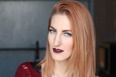 Parlak makyajlı, kızıl, pasaklı kadının stüdyo portresi. 