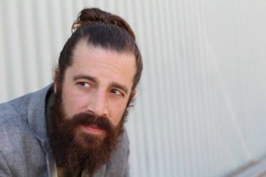 Tarz sahibi sakallı hippi modeli. Erkek saç stili, sokakta yaşam tarzı, tarlanın derinliği.