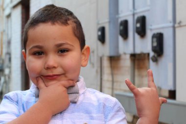 Açık havada, papyon takan şirin bir çocuğun portresi.