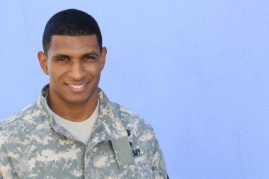 Mavi duvarın önünde üniformalı yakışıklı Afro-Amerikan askerinin yakın plan portresi