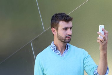 Kareli gömlekli genç bir adamın portresi ve telefonda konuşan Cyan süveteri. 