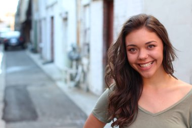 Açık havada duran melez üniversite öğrencisinin portresi.