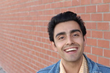 Kırmızı tuğla duvarın arka planında iyi bir adamın yakın plan portresi.