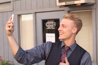 İngiliz centilmen güzellik konsepti. Dışarıda telefon kullanan genç ve yakışıklı bir adamın portresi. 