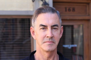 Siyah gömlekli yakışıklı olgun bir adamın yakın plan portresi.