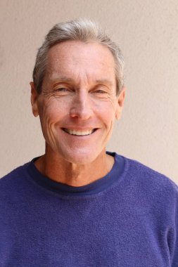 Kameraya bakan mor kazaklı yakışıklı olgun bir adamın yakın plan portresi.