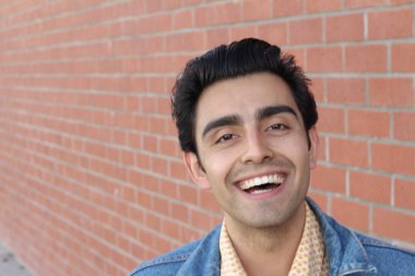 Kırmızı tuğla duvarın arka planında iyi bir adamın yakın plan portresi.