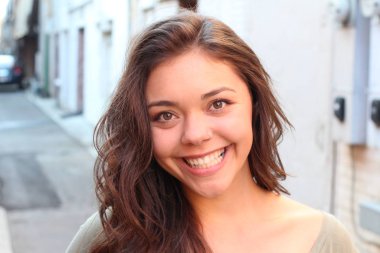 Açık havada duran melez üniversite öğrencisinin portresi.