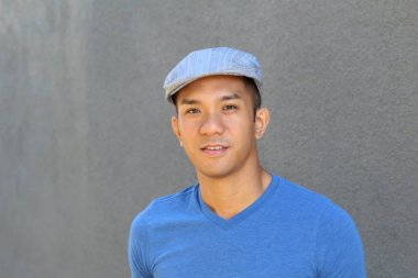 Karışık ırktan yakışıklı genç bir adamın yakın plan portresi. Sokakta günlük kıyafetlerle poz veriyor.