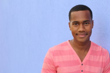 Yakışıklı, Afro-Amerikan, sıradan giyinmiş genç bir adamın yakın plan portresi.