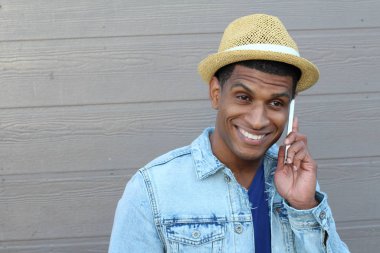 Yakışıklı, Afro-Amerikan bir adamın günlük kıyafetlerle sokakta telefonla konuşmasının yakın çekimi.