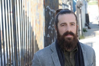 Tarz sahibi sakallı hippi modeli. Erkek saç stili, sokakta yaşam tarzı, tarlanın derinliği.