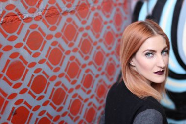 Parlak makyajlı, kızıl, pasaklı kadının stüdyo portresi. 