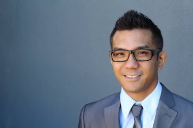 Portrait of young Asian man with glasses in office smiling