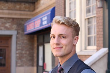 İngiliz centilmen güzellik konsepti. Dışarıda poz veren genç ve yakışıklı bir adamın portresi.