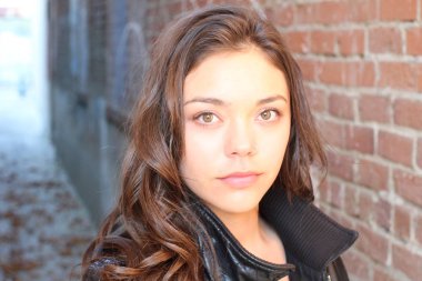 Açık havada duran melez üniversite öğrencisinin portresi.