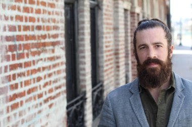 Tarz sahibi sakallı hippi modeli. Erkek saç stili, sokakta yaşam tarzı, tarlanın derinliği.