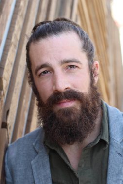 Tarz sahibi sakallı hippi modeli. Erkek saç stili, sokakta yaşam tarzı, tarlanın derinliği.