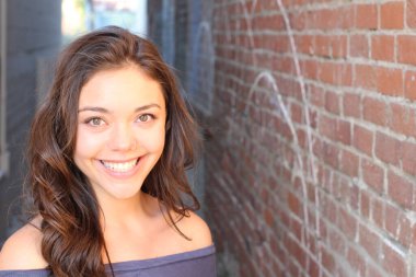 Açık havada duran melez üniversite öğrencisinin portresi.