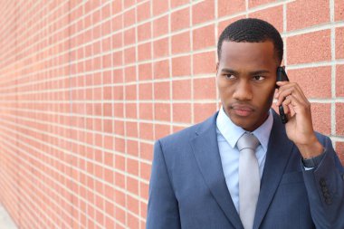 Yakışıklı Afro-Amerikan iş adamının yakın plan portresi tuğla duvarın önünde.