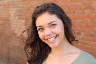 Portrait of beautiful female teenager on brick wall background 