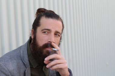 Tarz sahibi sakallı hippi modeli. Erkek saç stili, sokakta yaşam tarzı, tarlanın derinliği.