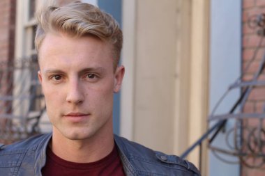 Bulanık şehir klasiği olan yakışıklı sarışın bir adamın yakın portresi.