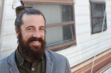 Tarz sahibi sakallı hippi modeli. Erkek saç stili, sokakta yaşam tarzı, tarlanın derinliği.