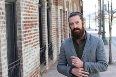 Tarz sahibi sakallı hippi modeli. Erkek saç stili, sokakta yaşam tarzı, tarlanın derinliği.