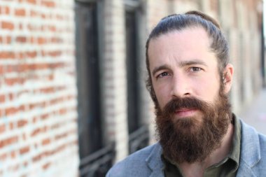 Tarz sahibi sakallı hippi modeli. Erkek saç stili, sokakta yaşam tarzı, tarlanın derinliği.