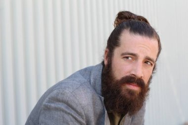 Tarz sahibi sakallı hippi modeli. Erkek saç stili, sokakta yaşam tarzı, tarlanın derinliği.