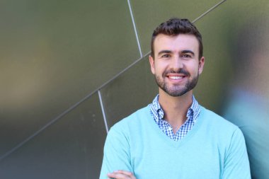 İşaretli gömlekli genç bir adam portresi ve kolları çapraz duran cyan süveter.