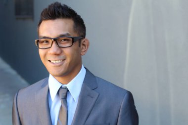 Portrait of young Asian man with glasses in office smiling