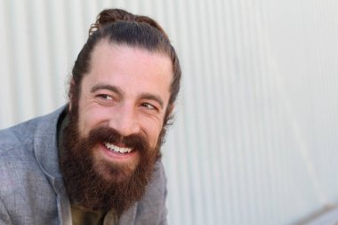 Tarz sahibi sakallı hippi modeli. Erkek saç stili, sokakta yaşam tarzı, tarlanın derinliği.