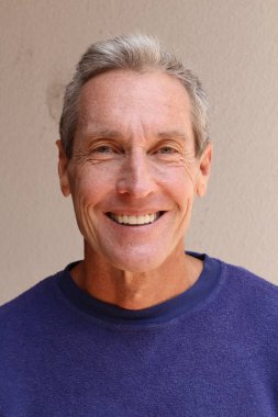 Kameraya bakan mor kazaklı yakışıklı olgun bir adamın yakın plan portresi.