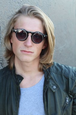 Sokakta uzun saçlı yakışıklı ve şık bir adamın yakın plan portresi.