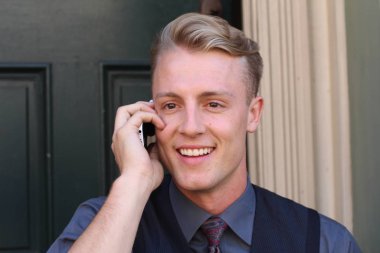 İngiliz centilmen güzellik konsepti. Dışarıda telefon kullanan genç ve yakışıklı bir adamın portresi. 