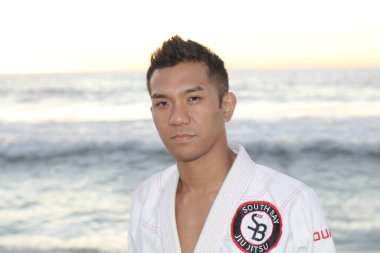 Deniz kıyısında dikilen kimonolu yakışıklı genç adamın yakın plan portresi.