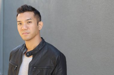 Karışık ırktan yakışıklı genç bir adamın yakın plan portresi. Sokakta günlük kıyafetlerle poz veriyor.