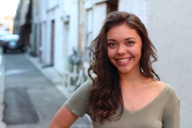 Açık havada duran melez üniversite öğrencisinin portresi.