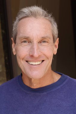 Kameraya bakan mor kazaklı yakışıklı olgun bir adamın yakın plan portresi.