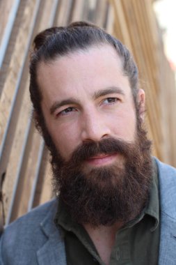 Tarz sahibi sakallı hippi modeli. Erkek saç stili, sokakta yaşam tarzı, tarlanın derinliği.