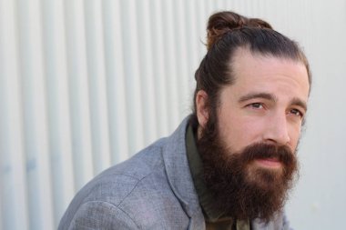 Tarz sahibi sakallı hippi modeli. Erkek saç stili, sokakta yaşam tarzı, tarlanın derinliği.